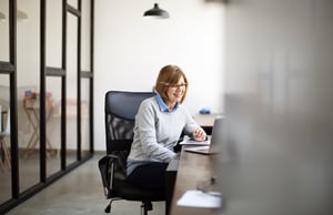 Ältere Frau an ihrem Schreibtisch arbeiten iStock-973715250