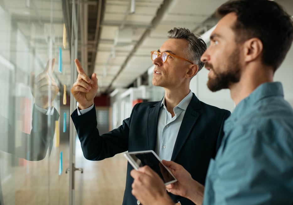 Hero - Geschäftsleute die sich mit der Planung  Gesprächen Ideendiskussionen Brainstorming treffen. Scrum mit Haftnotizen  Planungsboards im modernen Büro stehen. Agile Methodik-Konzept iStock-1325565887.jpg