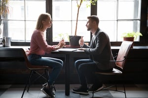 Männliche Versicherungsagentin verhandelt mit weiblicher Kundin im Café iStock-1309449042