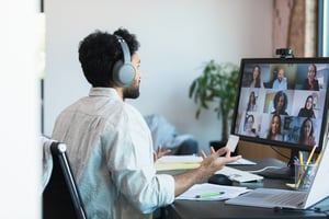 Mit kabellosen Kopfhörern leitet Mann Teambesprechung iStock-1359410914