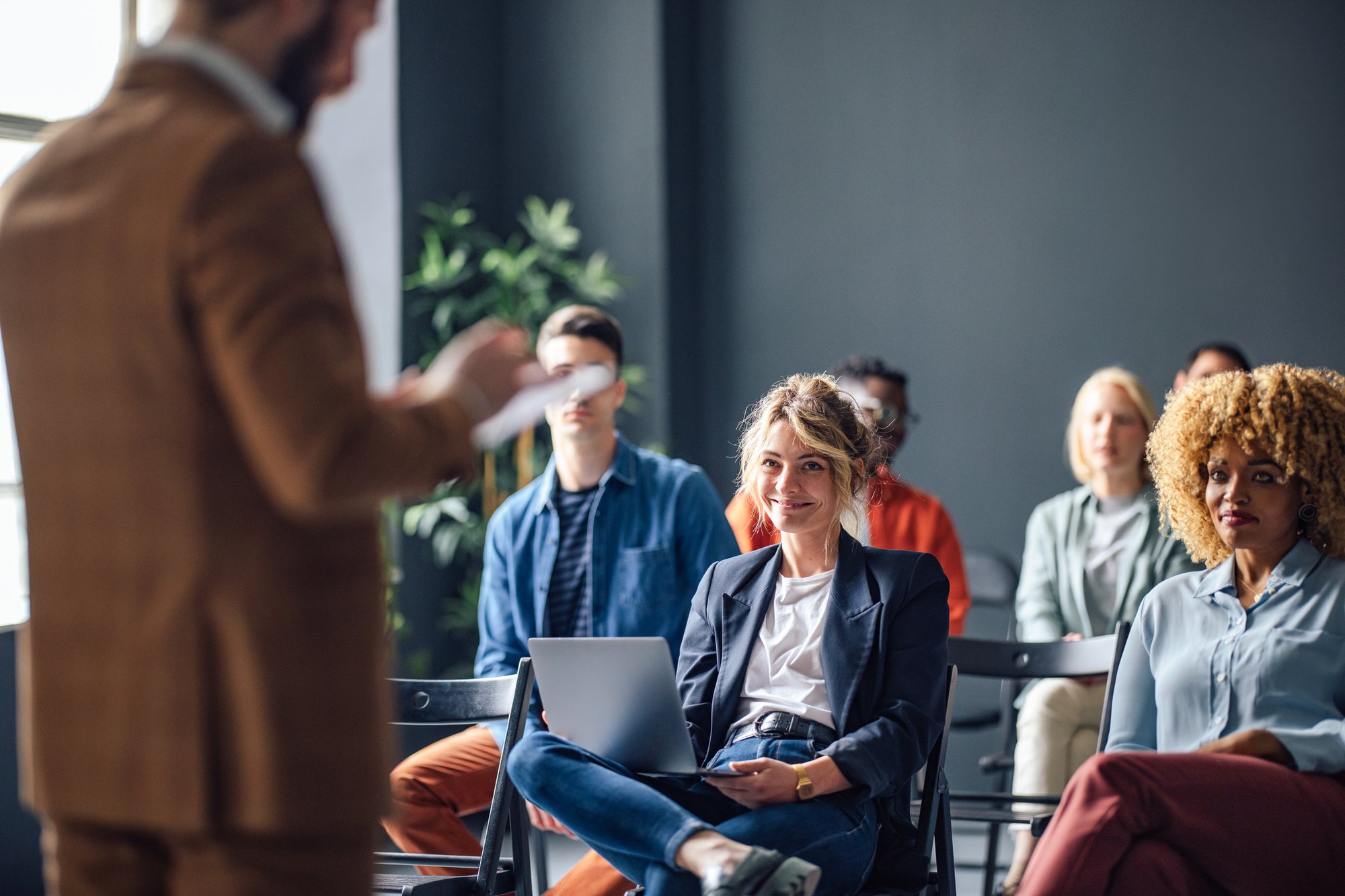 Gruppe fröhlicher Menschen auf einem Seminar iStock-1408304018