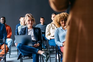 Glückliche Geschäftsleute, die auf einer Bildungsveranstaltung in ihrem Unternehmen sitzen iStock-1408517185