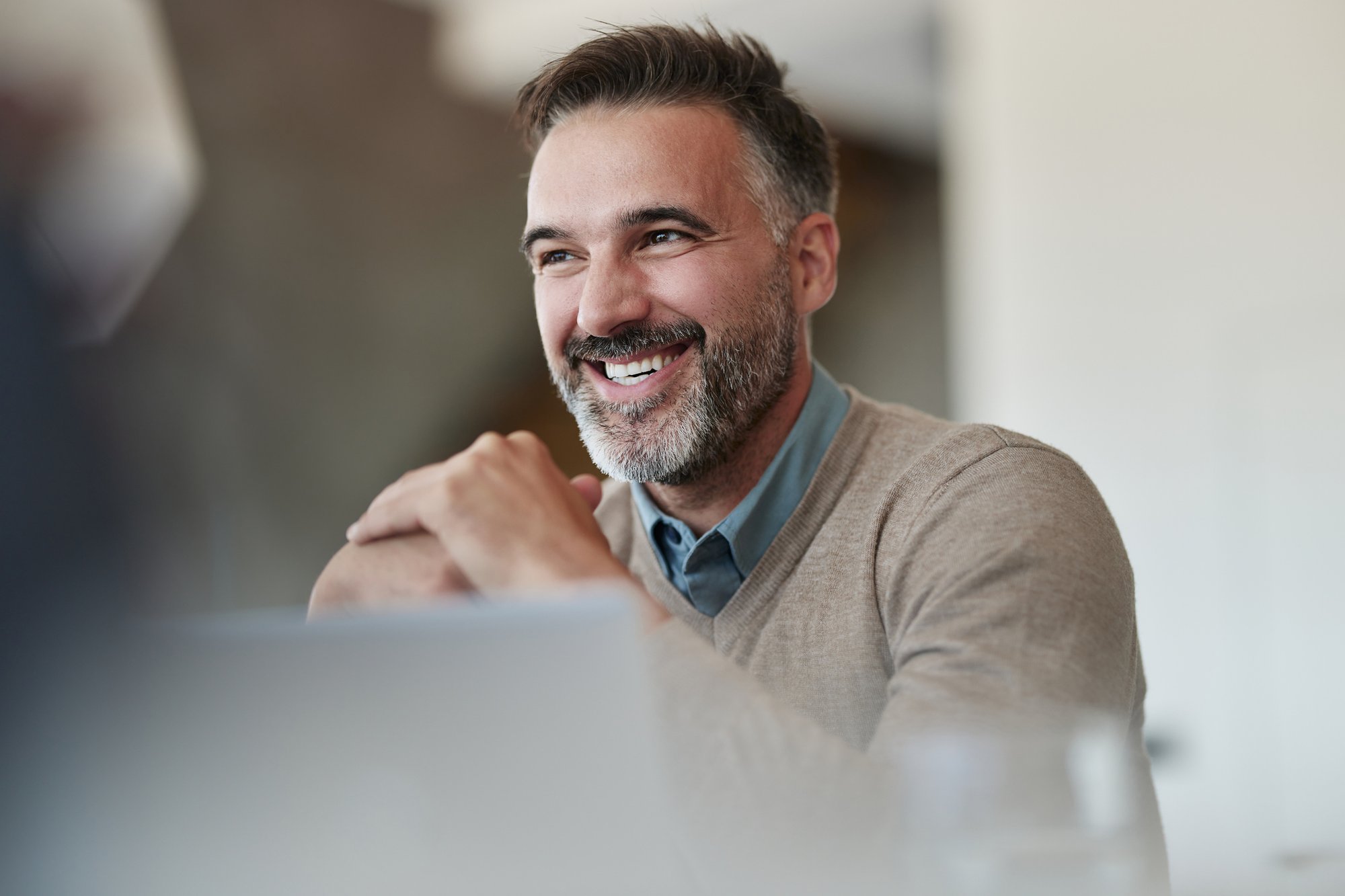 Glücklicher Geschäftsmann im mittleren Erwachsenenalter, der im Büro genießt. iStock-2180951990