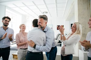 Mann umarmt Kollegen.Feiern im Büro nach erfolgreichen Pitch von Team.iStock-841337566