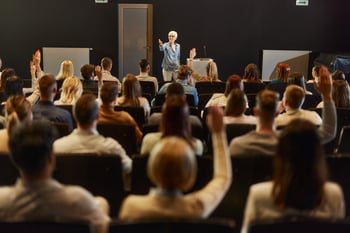 Ältere Geschäftsfrau hält VortragiStock-2175580409