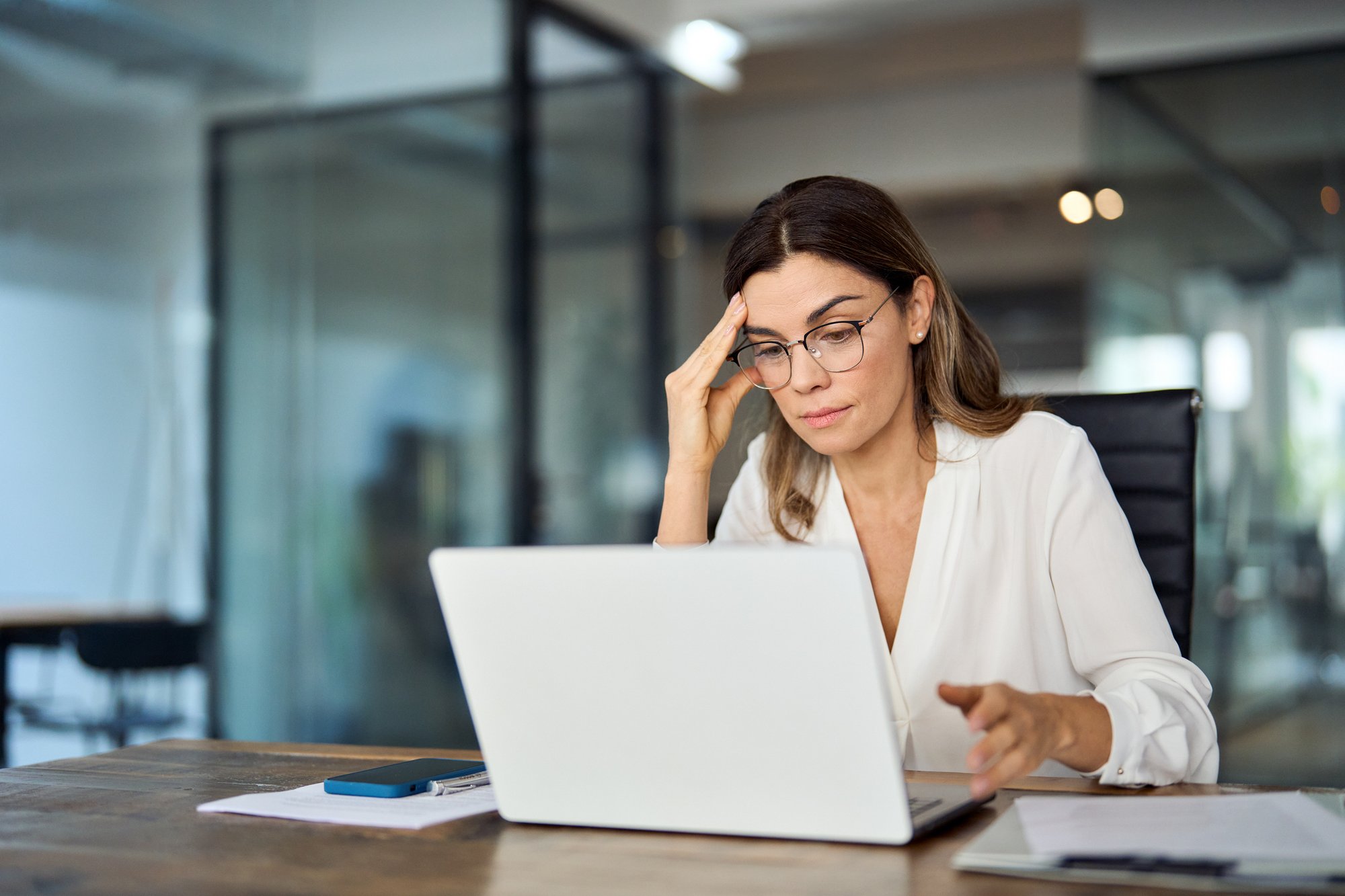Besorgte, müde Geschäftsfrau, die eine Brille trägt iStock-2004891058