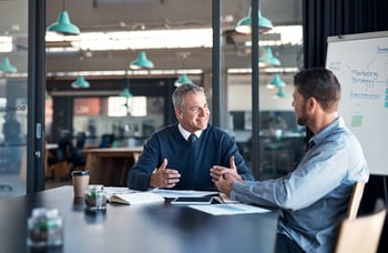 Zwei Geschäftsmänner besprechen im Meeting. Coaching. Lächelnd.iStock-1185859132