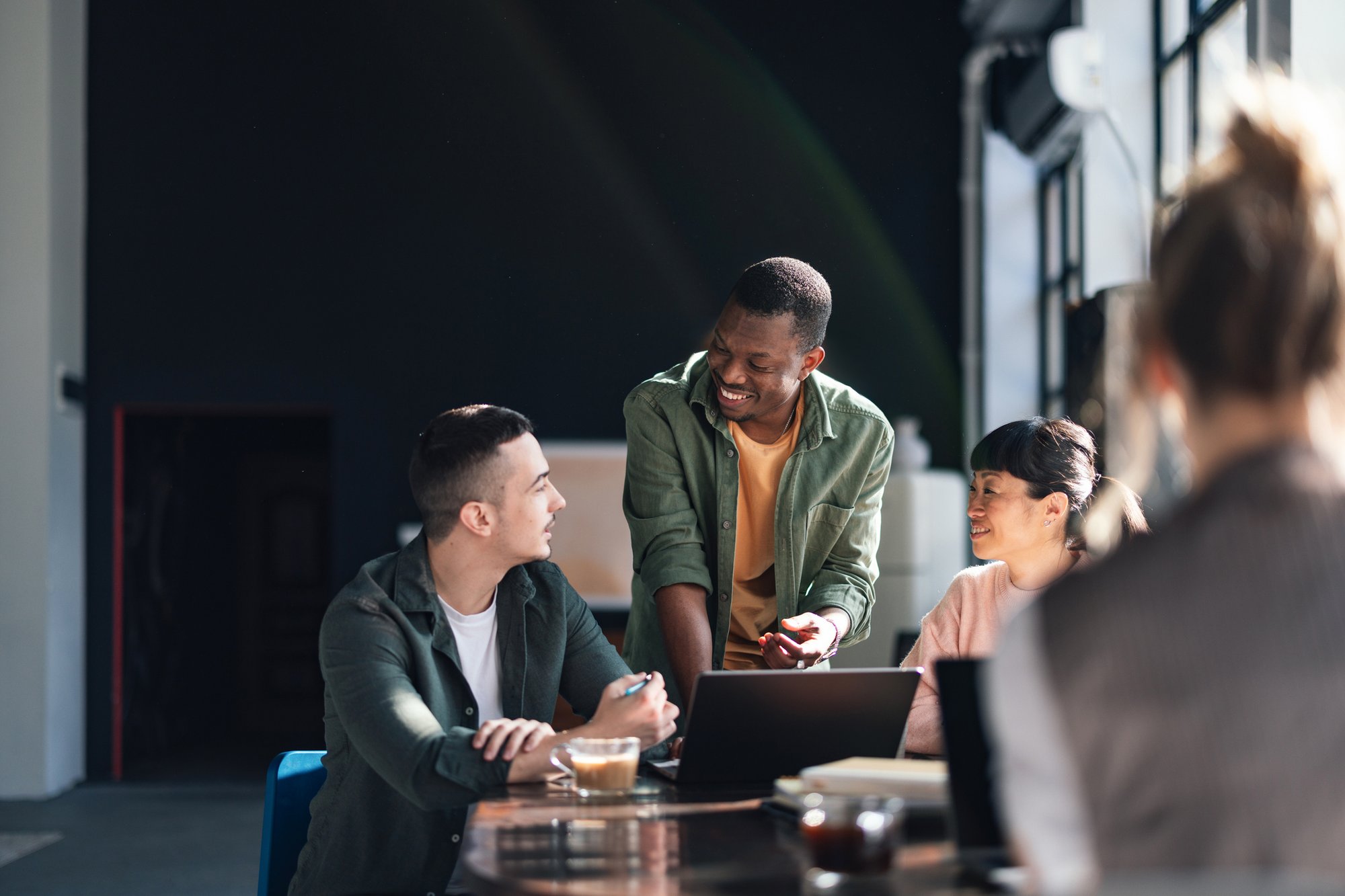 Diverses Team, das in einem modernen Co-Working-Space zusammenarbeitet iStock-2094337698