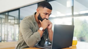 man and laptop with stress, headache and tired with a deadline or anxiety iStock-2149251025