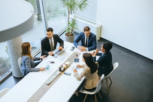 Team, das an einem Konferenztisch arbeitet iStock-2148122334