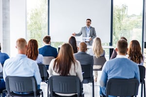 Geschäftsführer, der eine Rede auf einem Seminar im Vorstandssaal hält iStock-1340856781