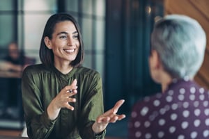 Two businesswomen talking in the office iStock-2155904673