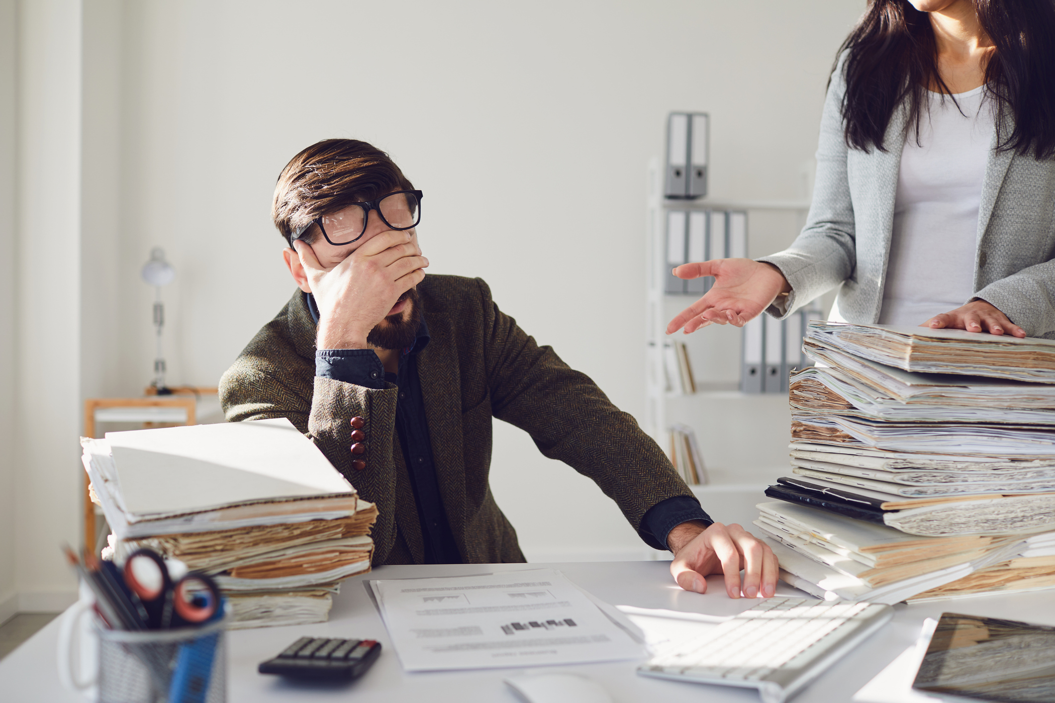 Arbeiter Geschäftsmann müde verärgert empört unglücklich sitzen bei der Arbeit am Arbeitsplatz im Büro iStock-1265182212