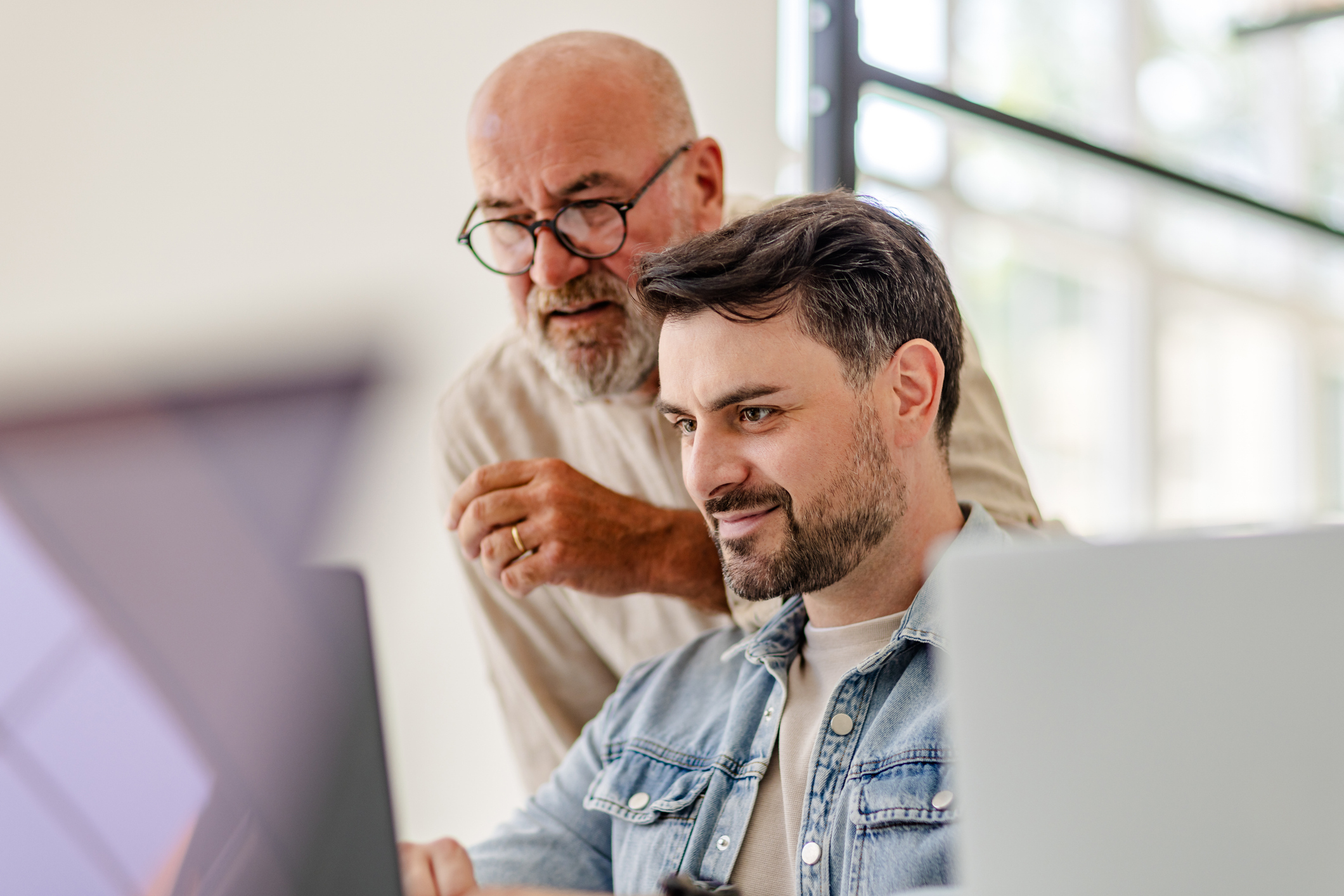 Mann mit Brille Zusammenarbeit in einem Büro mit Fachleuten, die an Technologieprojekten arbeiten iStock-2223410802