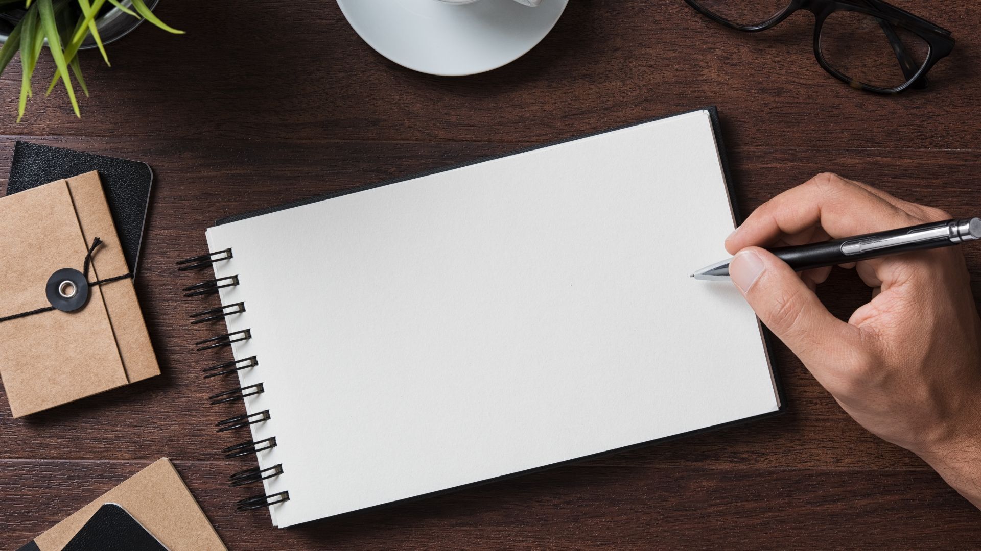 businessman-writing-on-blank-notebook_1920x1080