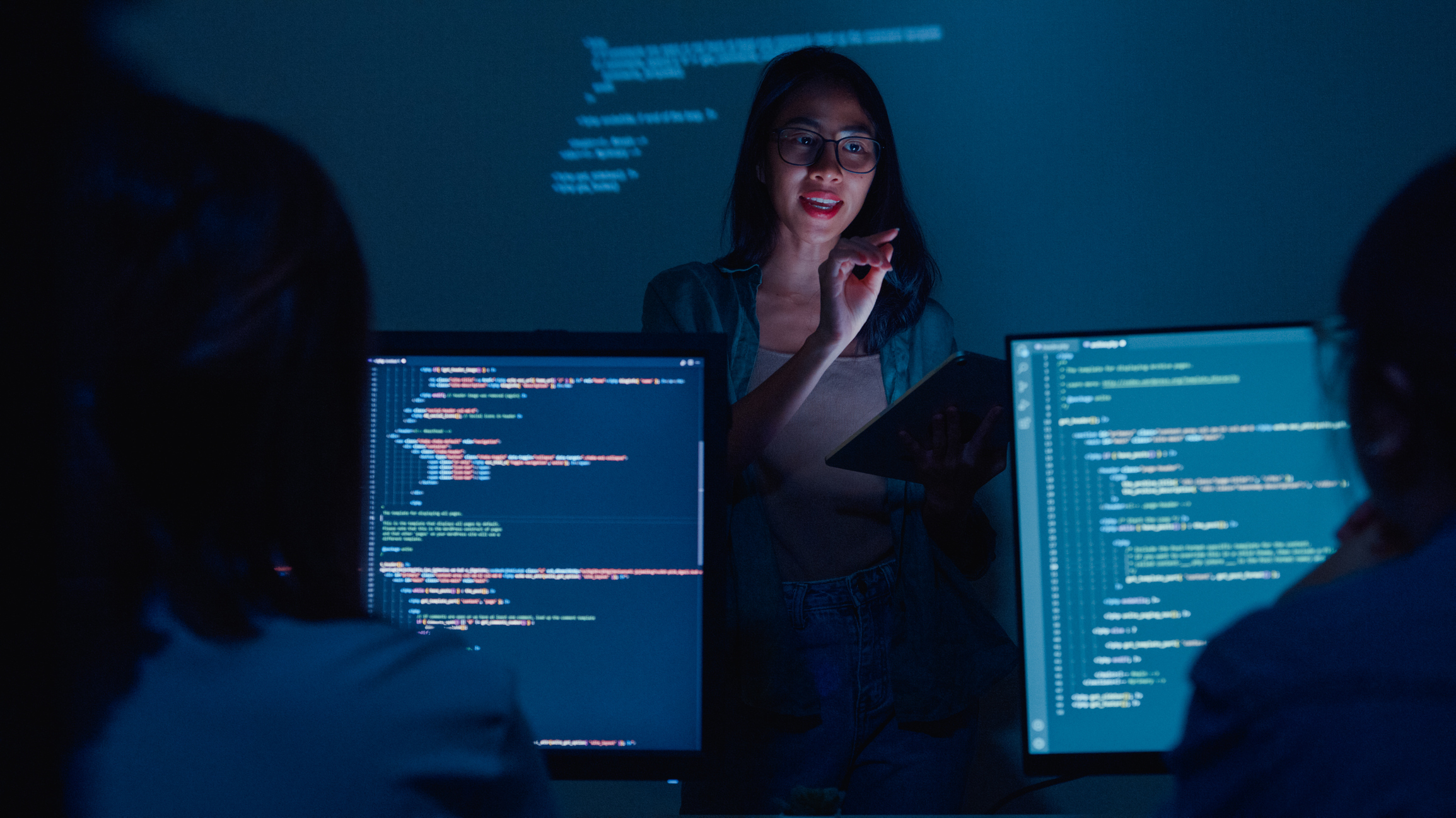 Junge Softwareentwicklerinnen betreuen Führungskräfte, die nachts mit dem FührungsteamiStock-1459731733