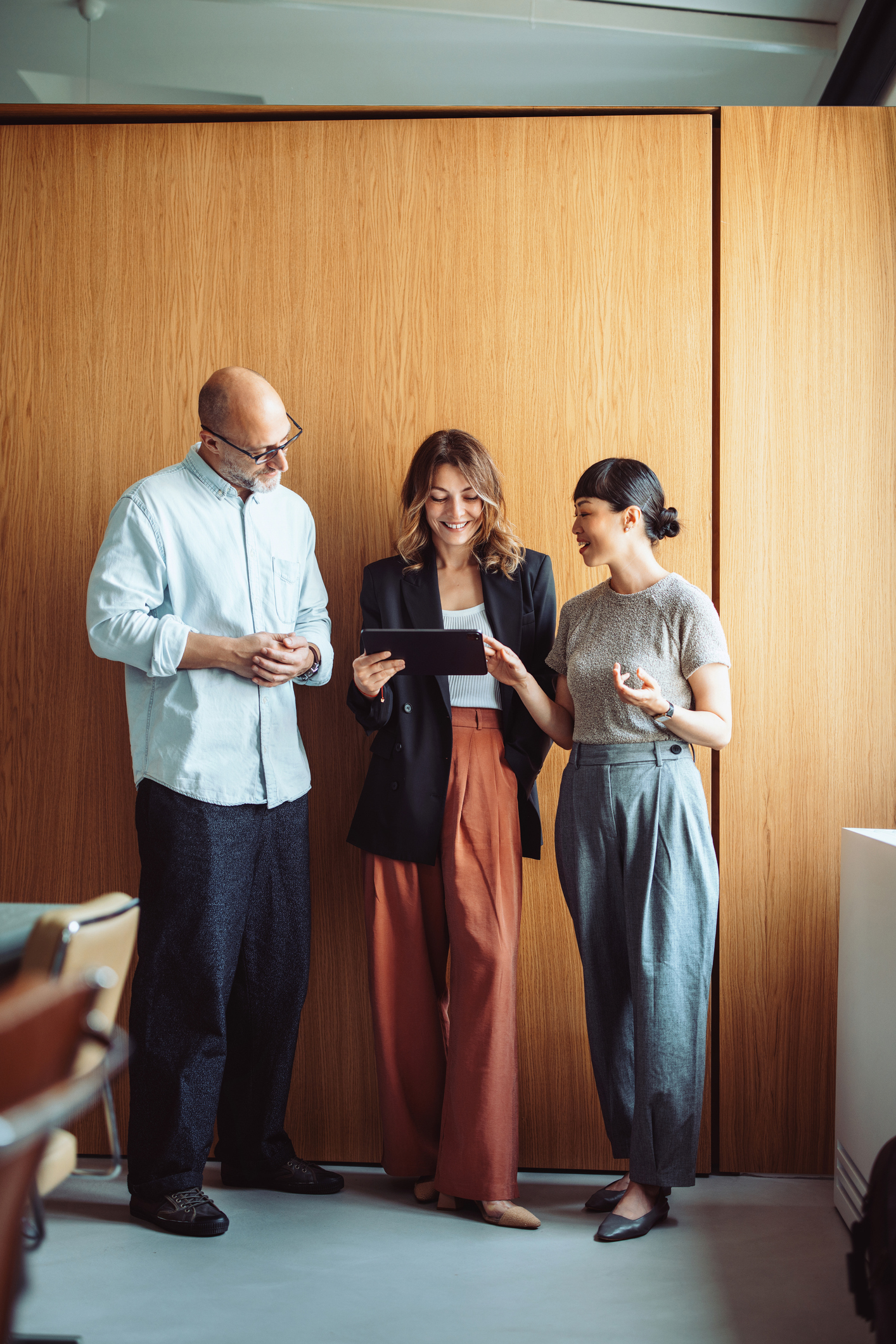 Kollegen diskutieren über die Arbeit auf dem Tablet  iStock-2161896237