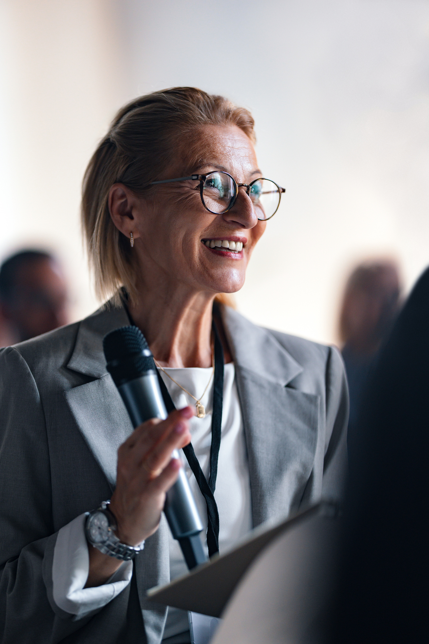 Professionelle Frau, die auf einer Business-Konferenzveranstaltung spricht iStock-2174029765