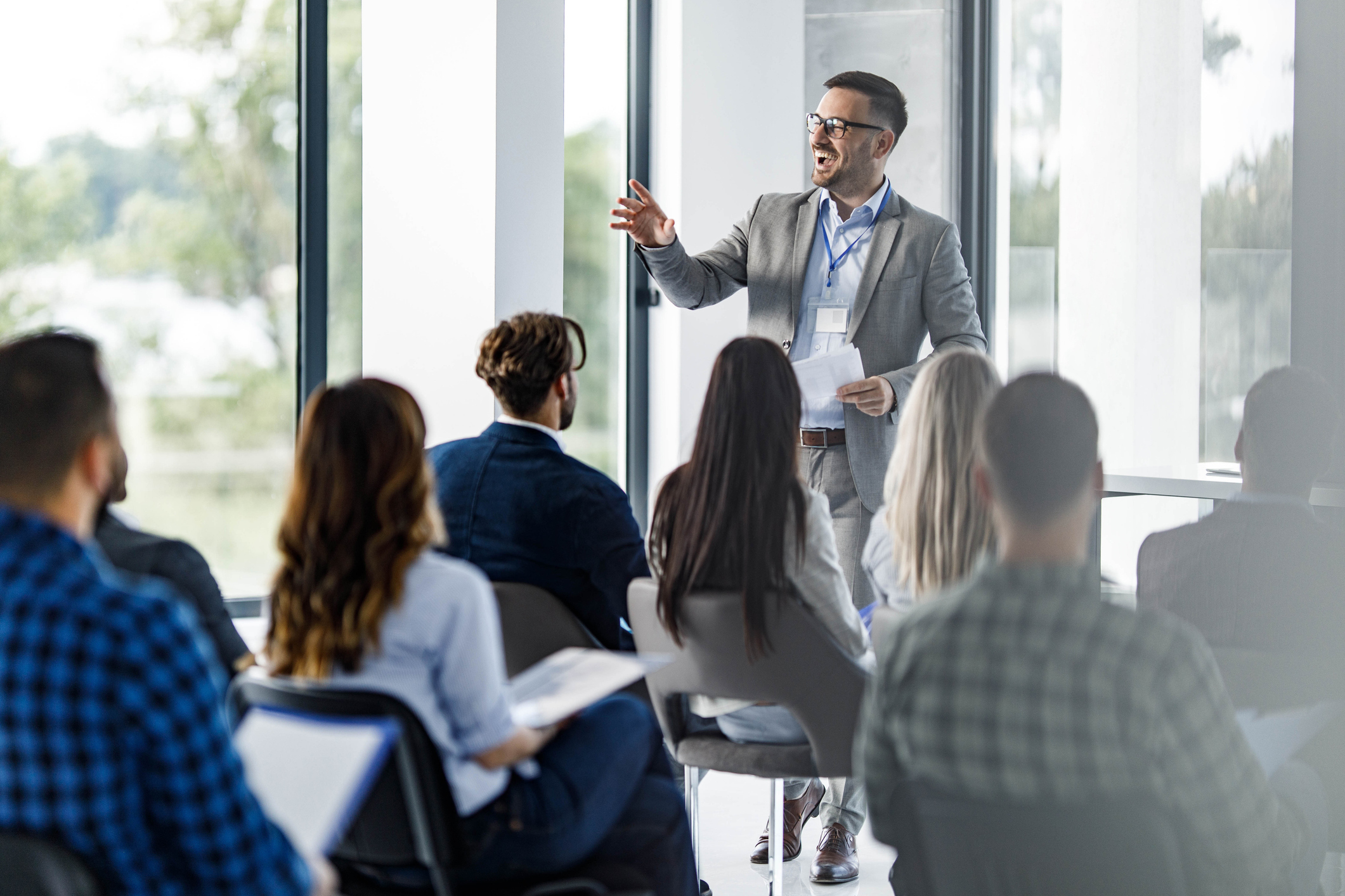 Happy business leader talking to group of his colleagues iStock-2116544916