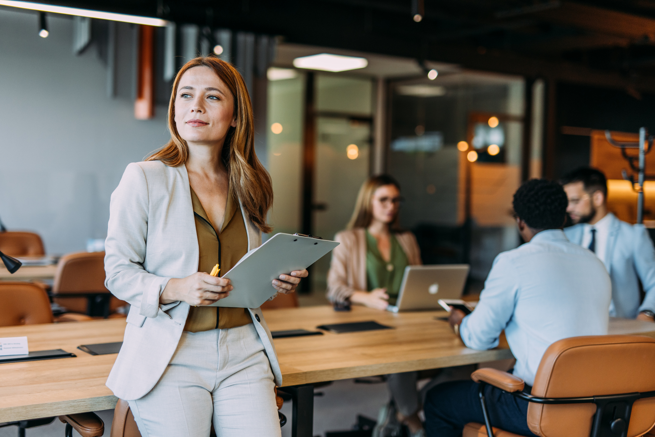 Confident businesswoman and her team iStock-2169869893