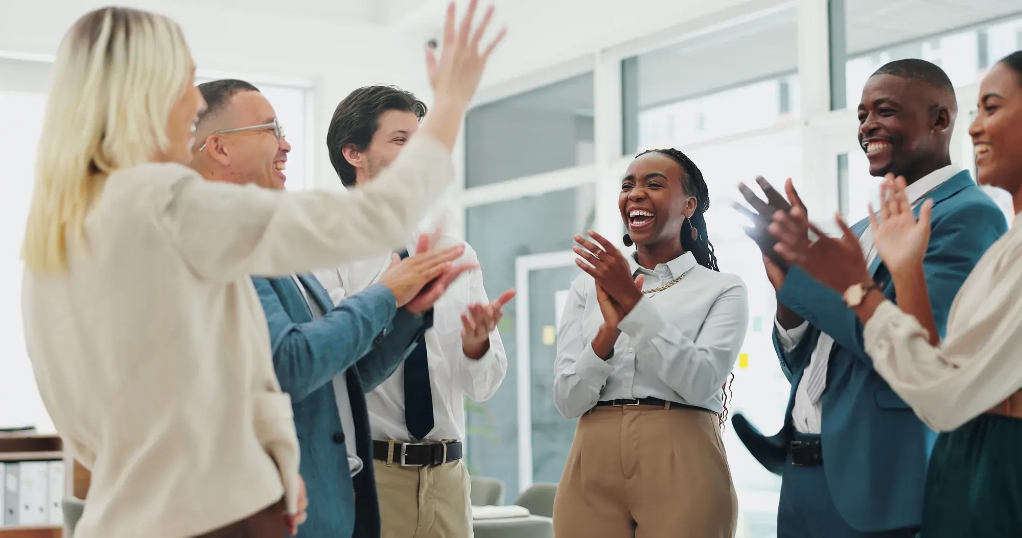 Happy, business people and applause with congratulations for winning, promotion or success at office. Group of employees clapping with smile for collaboration, teamwork or bonus together at workplace iSt