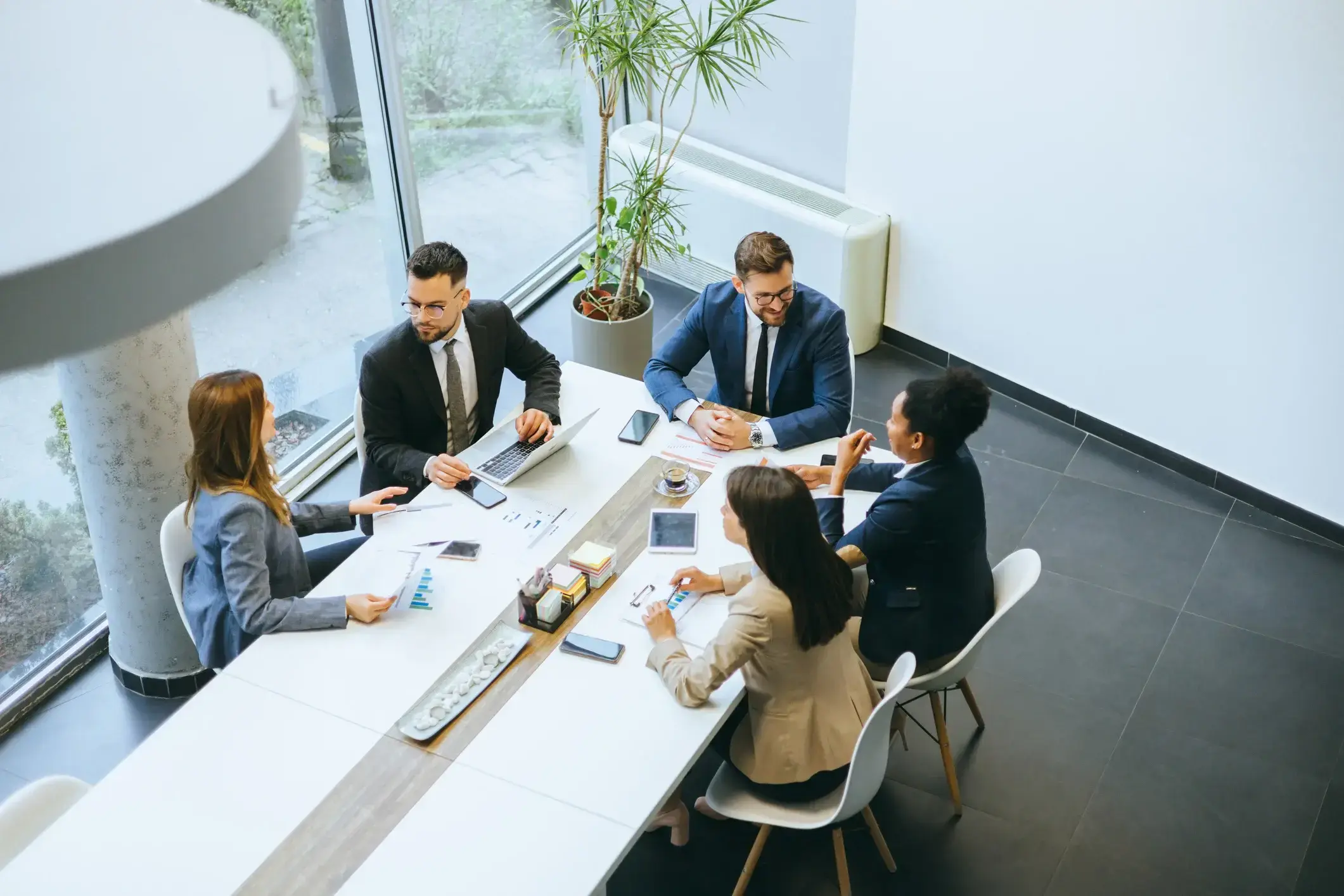 Team, das an einem Konferenztisch arbeitet iStock-2148122334